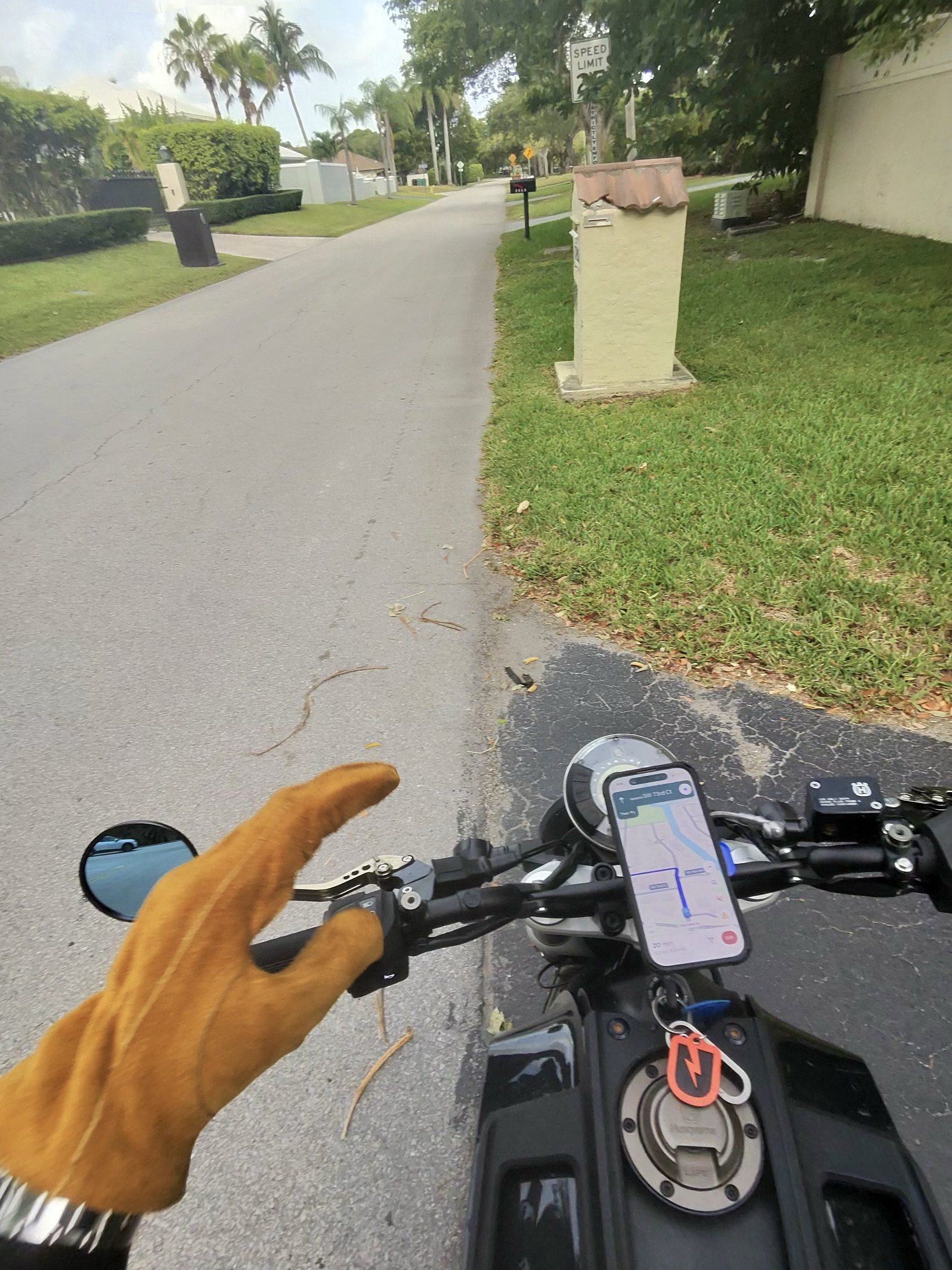 A gloved hand throwing a peace sign over the handlebars mid-ride