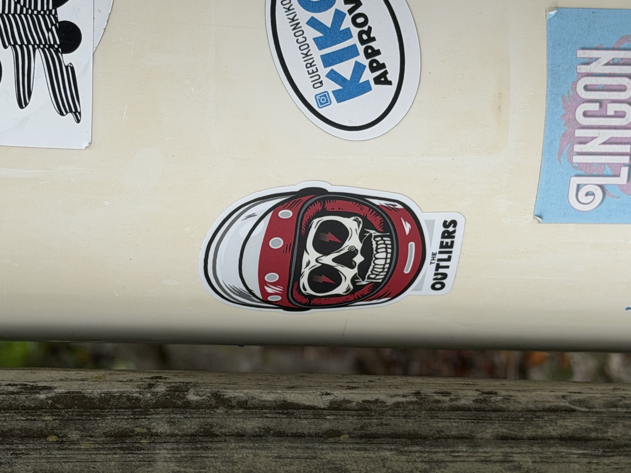 The Outliers skull-helmet sticker on a pole
